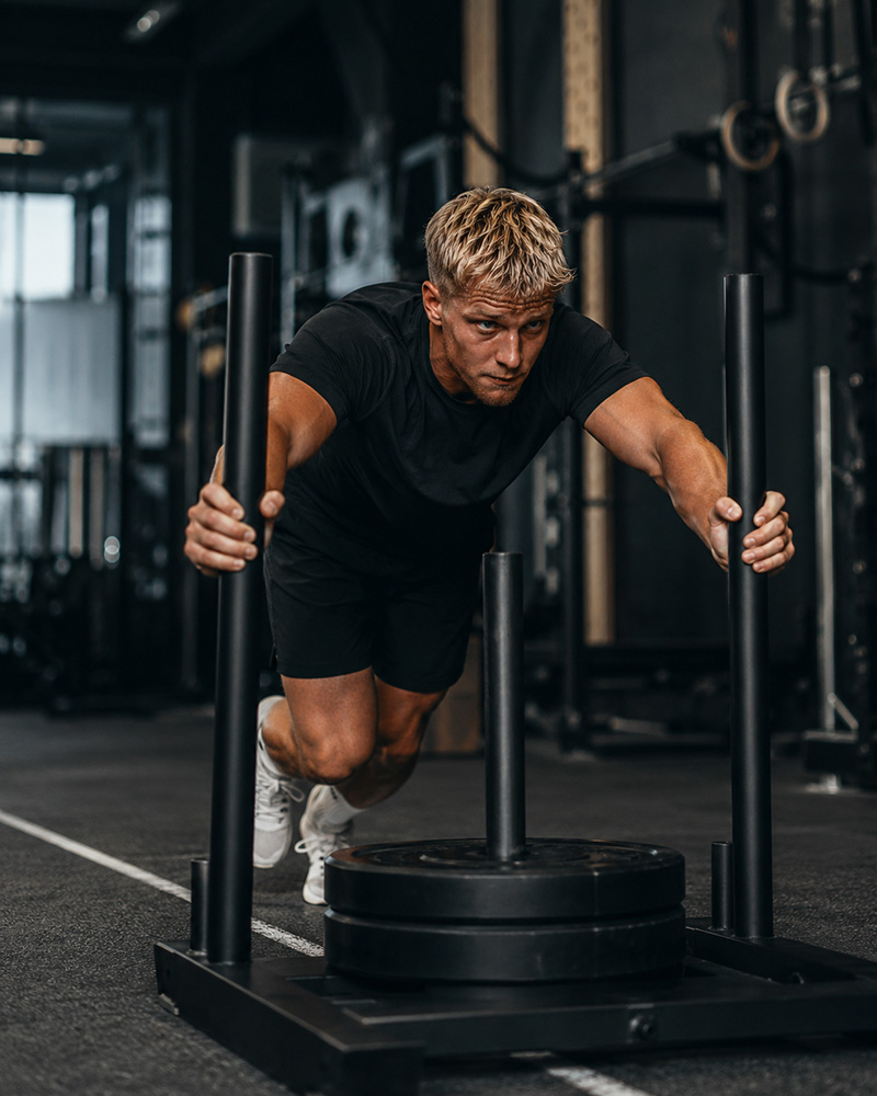 Fitnessfotograf tager billede af mand der træner
